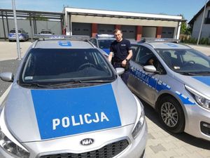 policjant stojący przy radiowozie