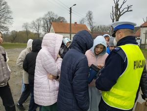 uczniowie stojący z policjantem