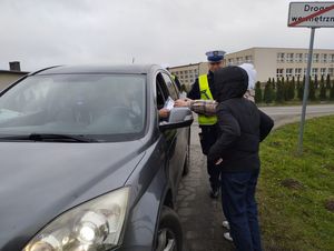 grupa dzieci wraz z policjantem przy samochodzie