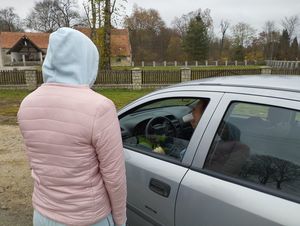 osoba stojąca przy samochodzie