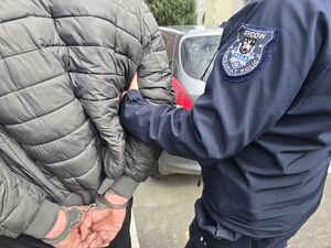 policjant trzyma mężczyznę za przedramię