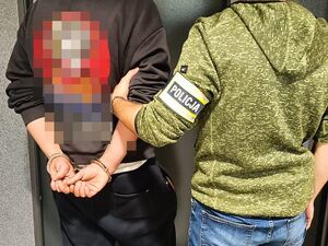 policjant z mężczyzną w kajdankach